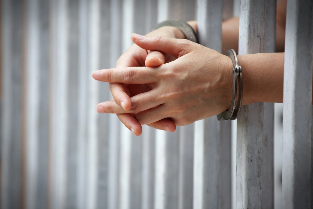 close up of prisoner hands in jail background.